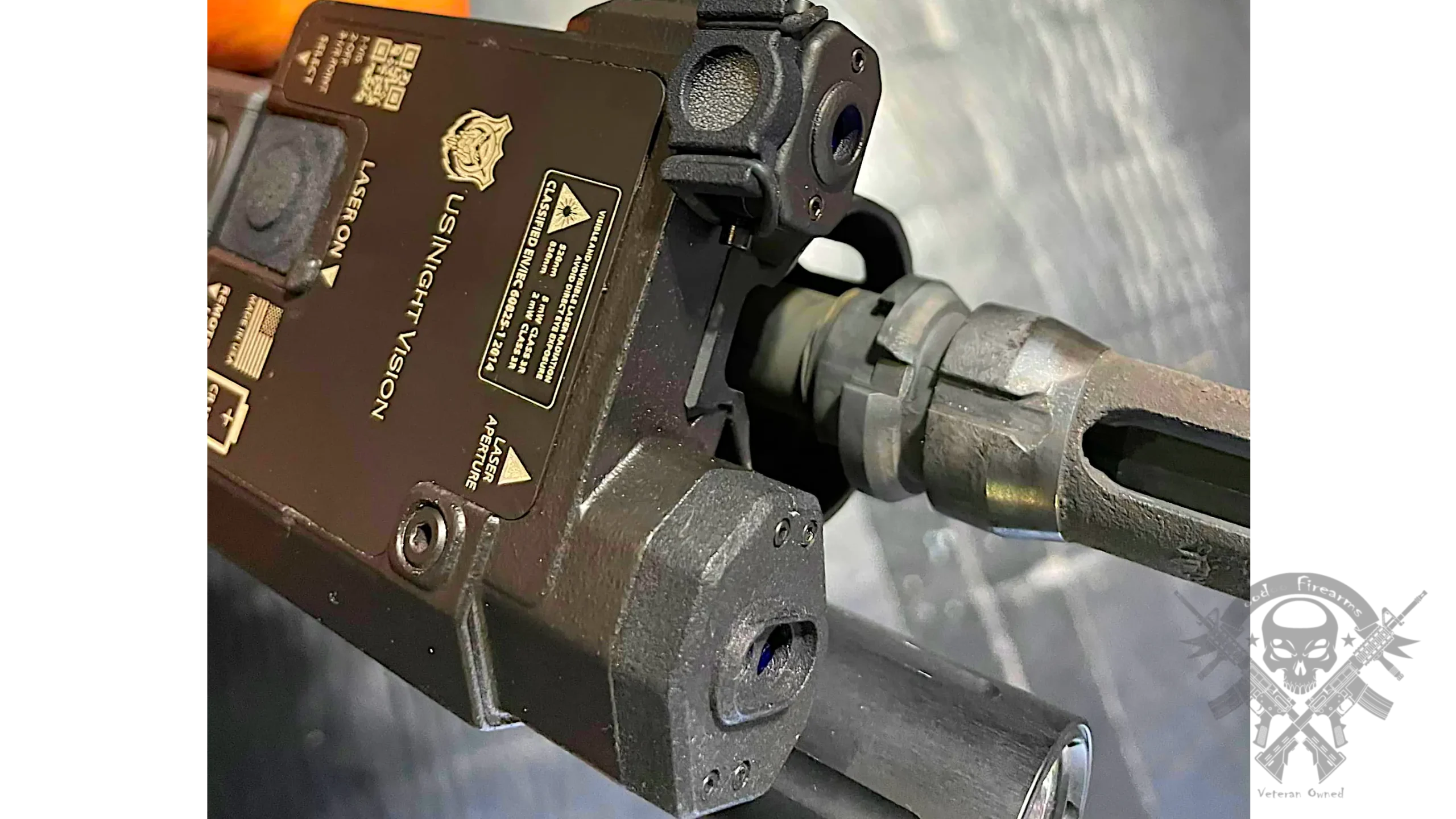 Mounted view of US Night Vision Designate IR-V on tactical rifle with optic and dual remote switch ports visible