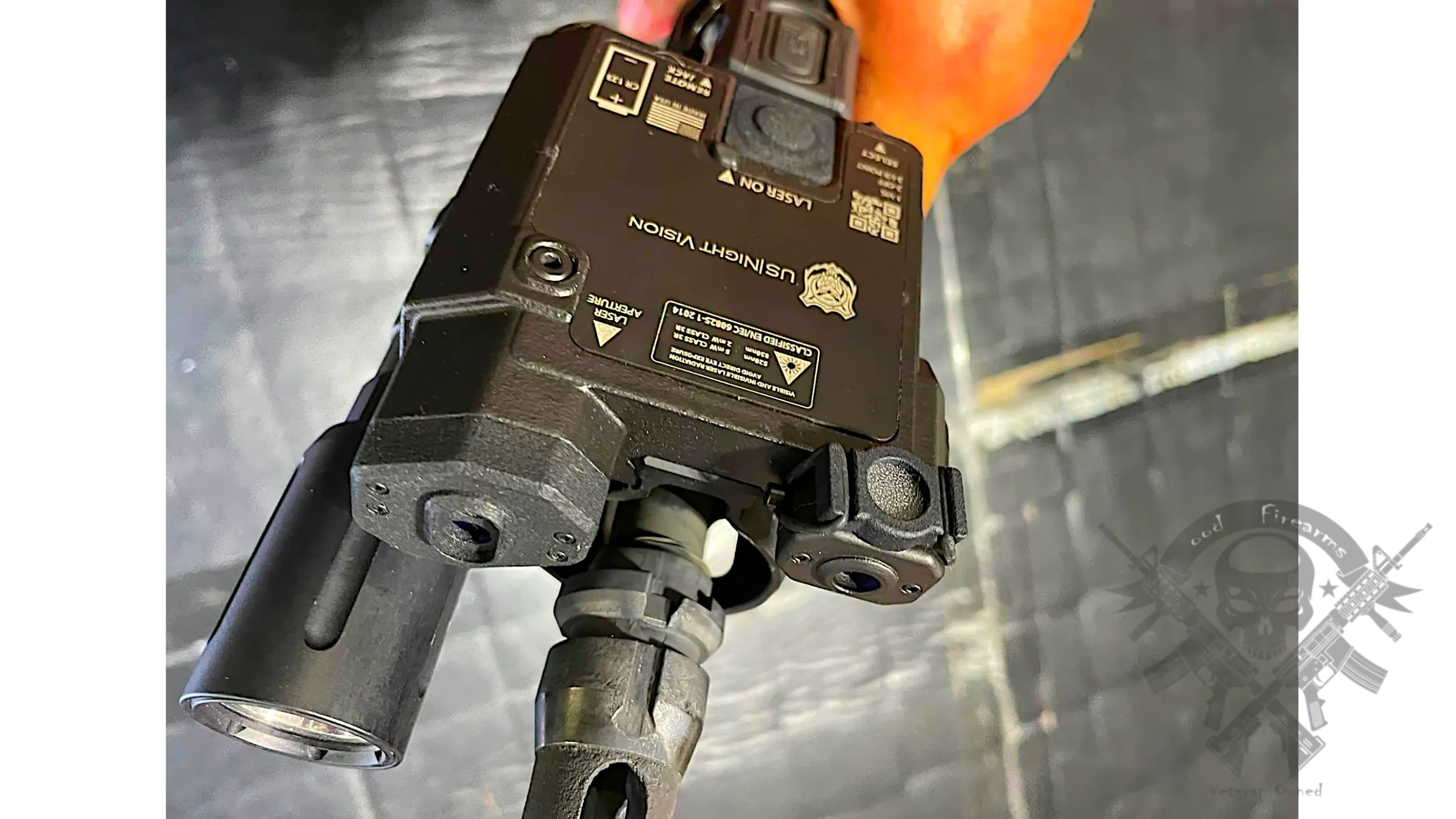 Angled view of US Night Vision Designate IR-V mounted on a suppressed AR-style rifle with optic and rail accessories