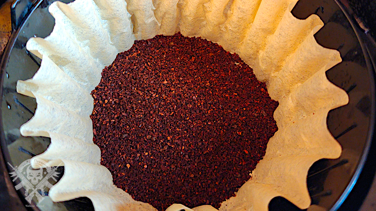 Freshly ground Gun Barrel Coffee MOAB blend in a paper filter basket, ready for brewing.