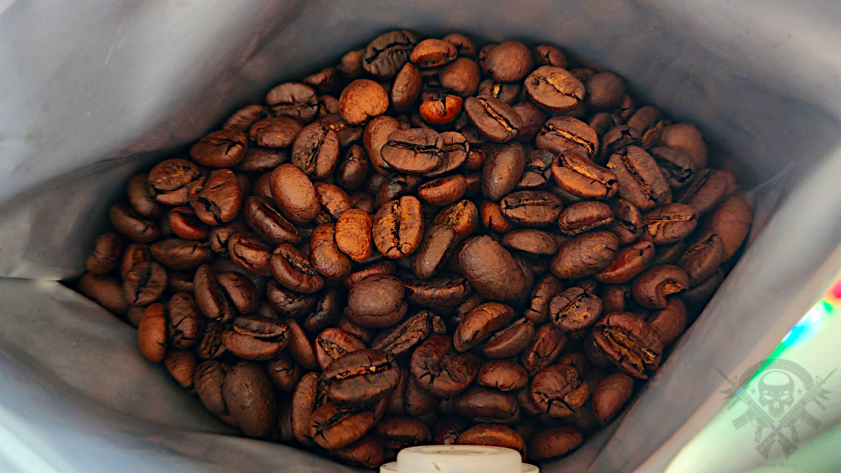 Fresh whole coffee beans inside an open Gun Barrel Coffee MOAB bag, showcasing bean quality and roast level.